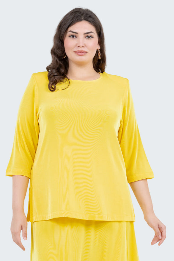Woman wearing a yellow outfit with a plain background