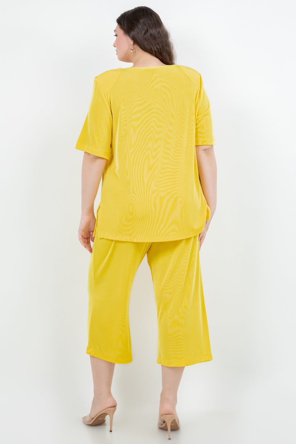 Woman wearing a yellow outfit on a white background
