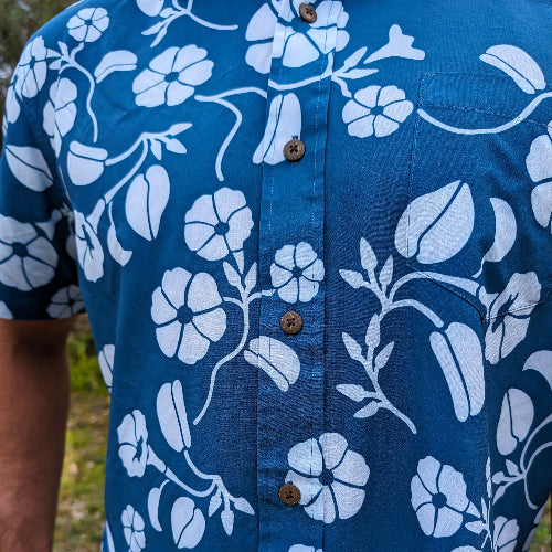 Blue shirt with white floral pattern worn by a person outdoors