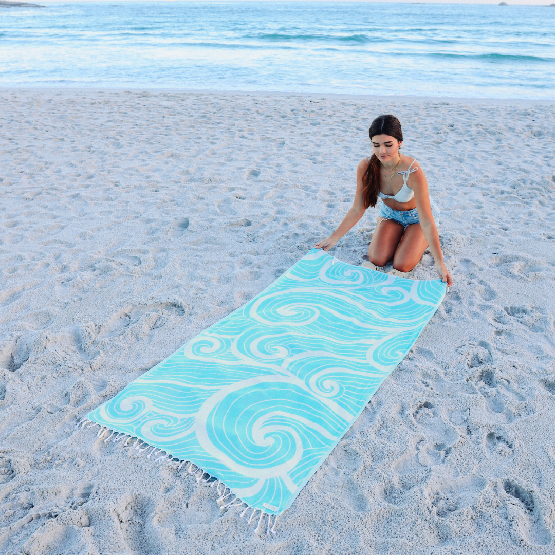 Woman on a beach with a blue and white patterned towel