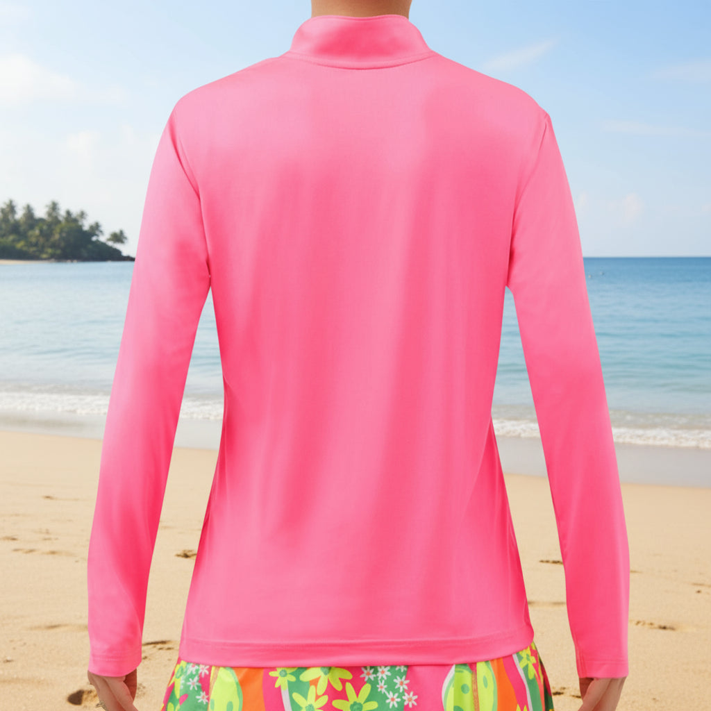Pink long-sleeve top worn by a person with colorful shorts on a white background