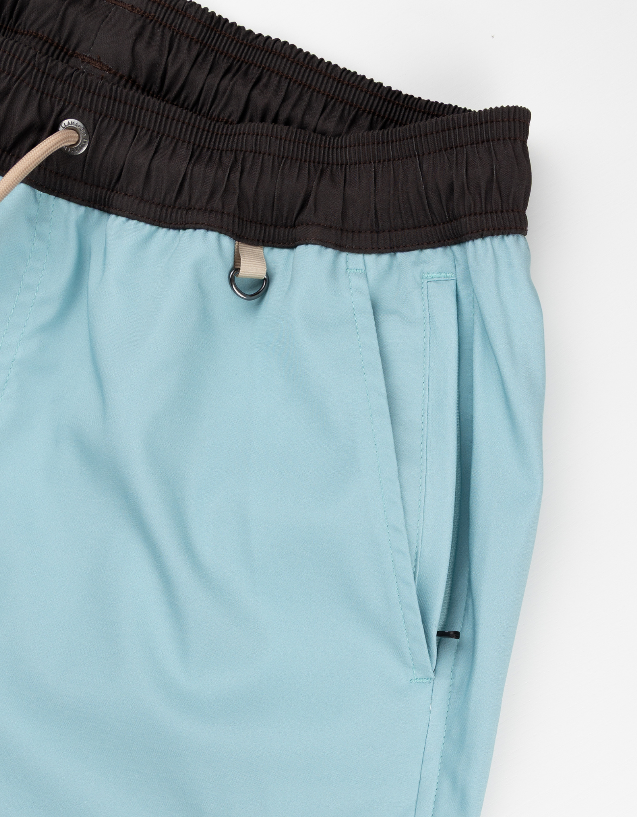 Light blue pants with a black waistband on a white background