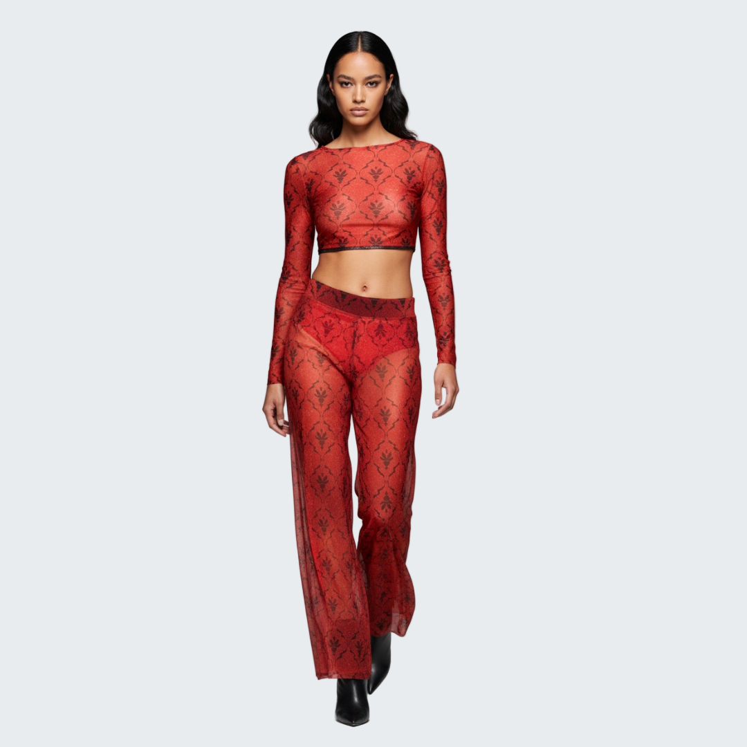 Model wearing a red lace outfit on a gray background