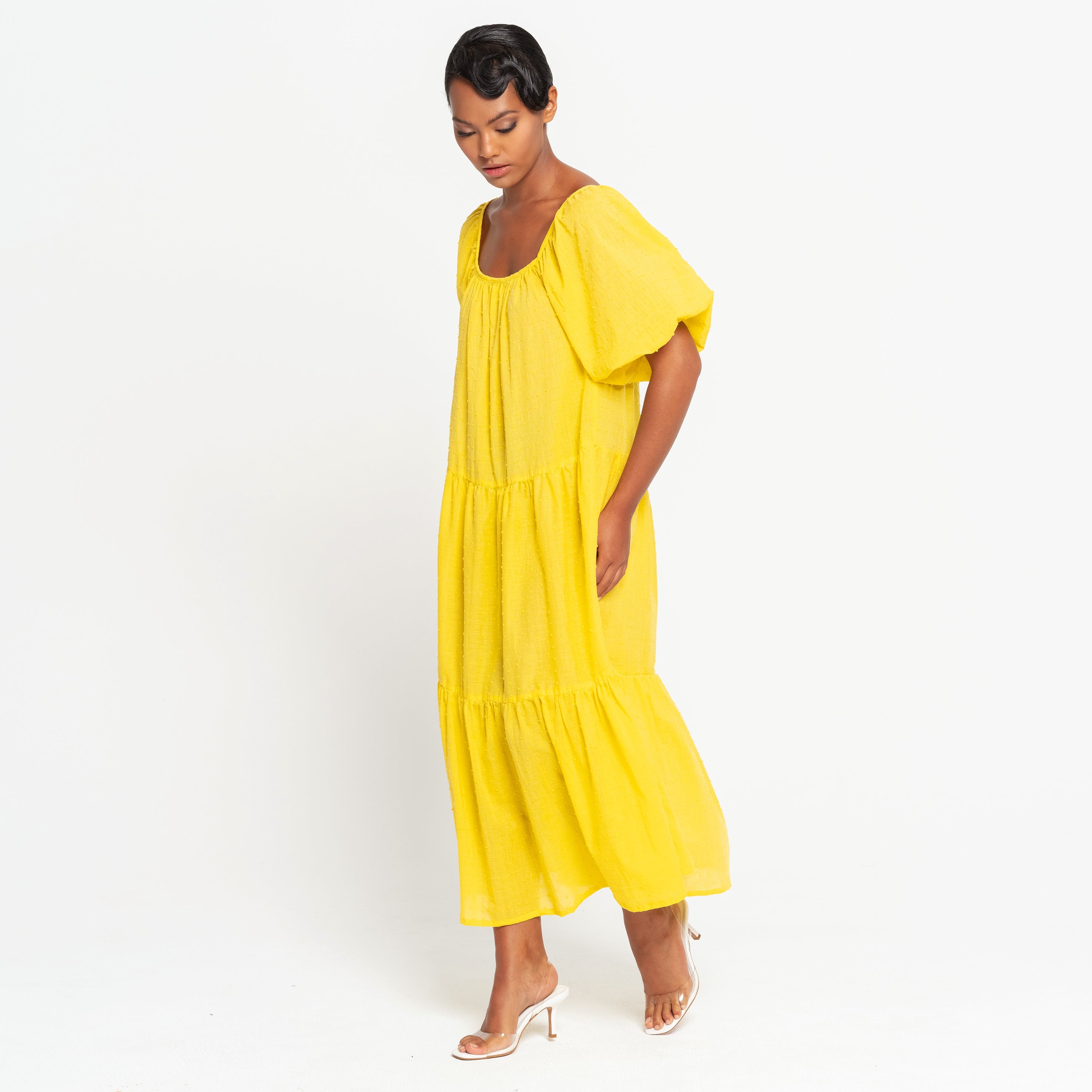 Woman wearing a yellow dress against a white background