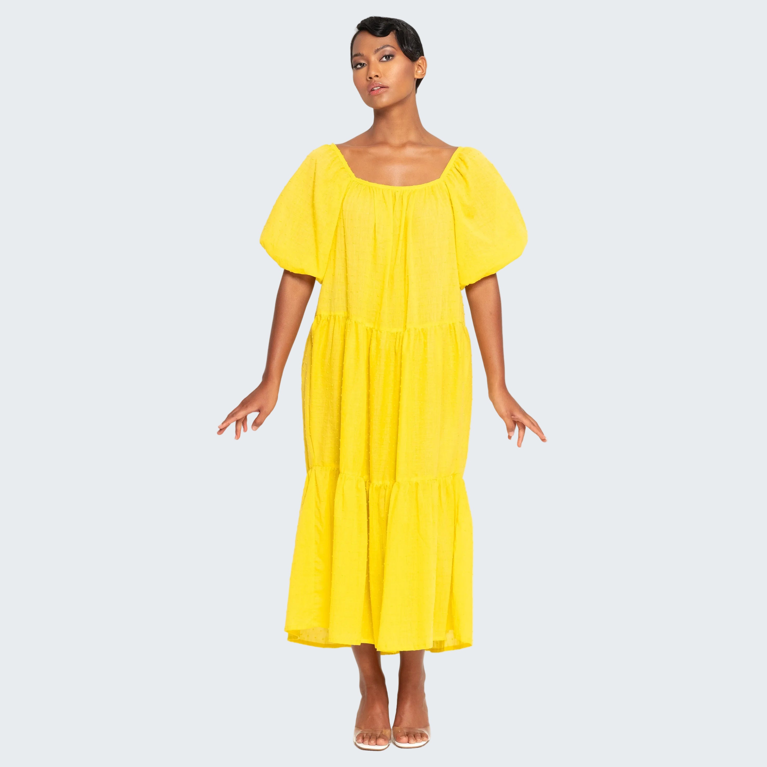 Woman wearing a yellow dress on a white background