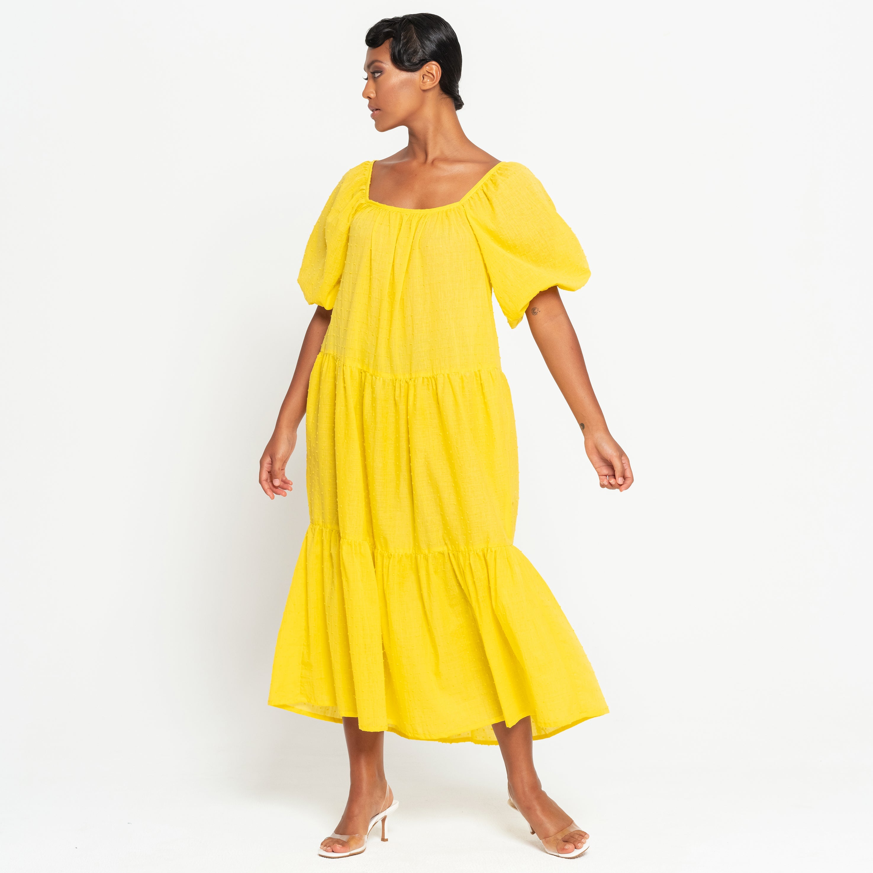 Woman wearing a yellow dress on a white background