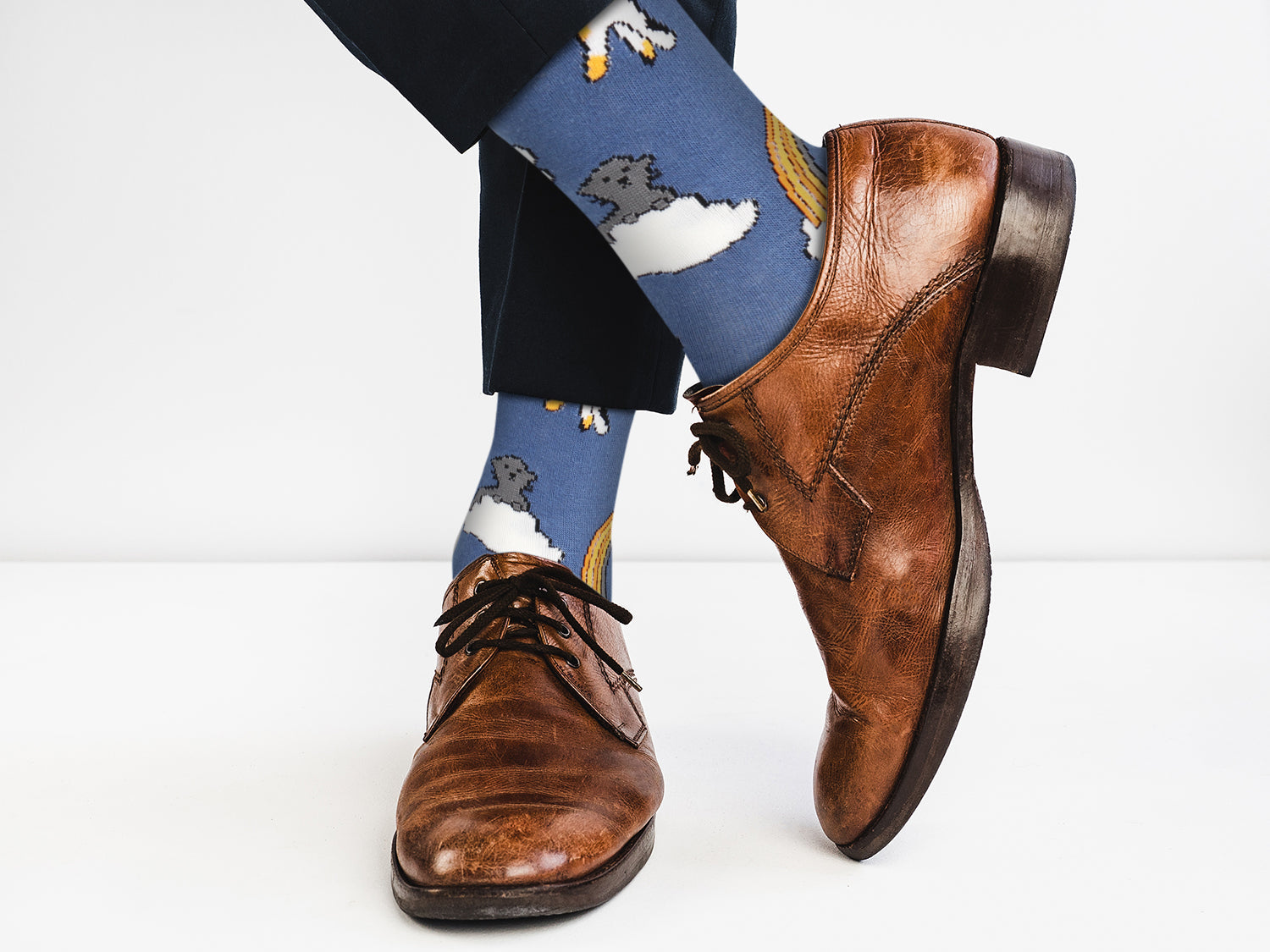 Brown leather shoes with blue socks featuring a dog design on a white background