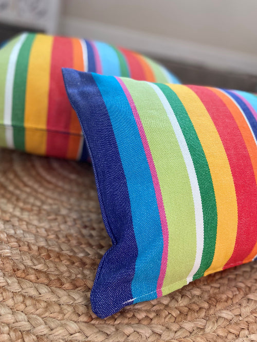 Colorful striped pillow on a textured surface