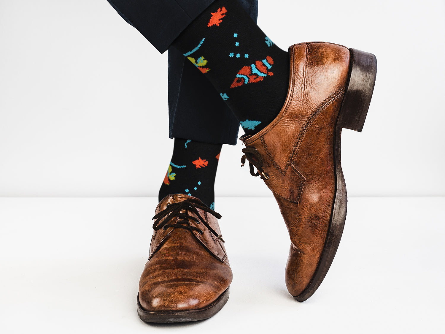 Brown dress shoes and colorful socks on a white background