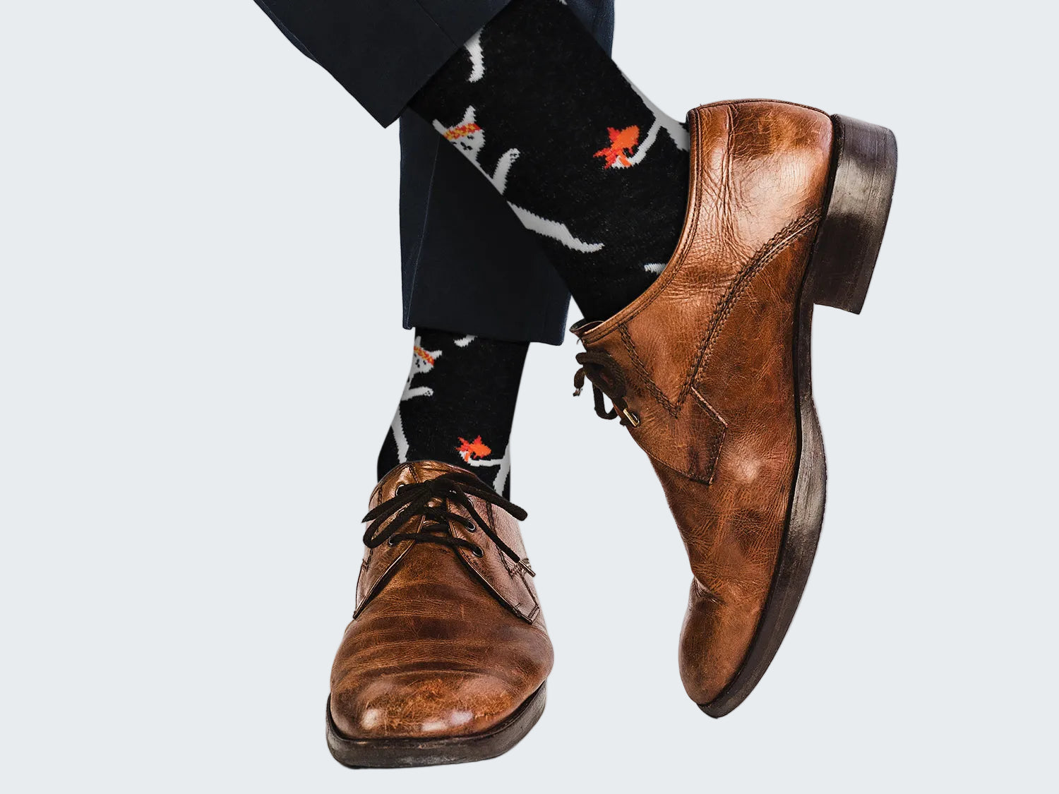 Brown dress shoes and patterned socks on a white background