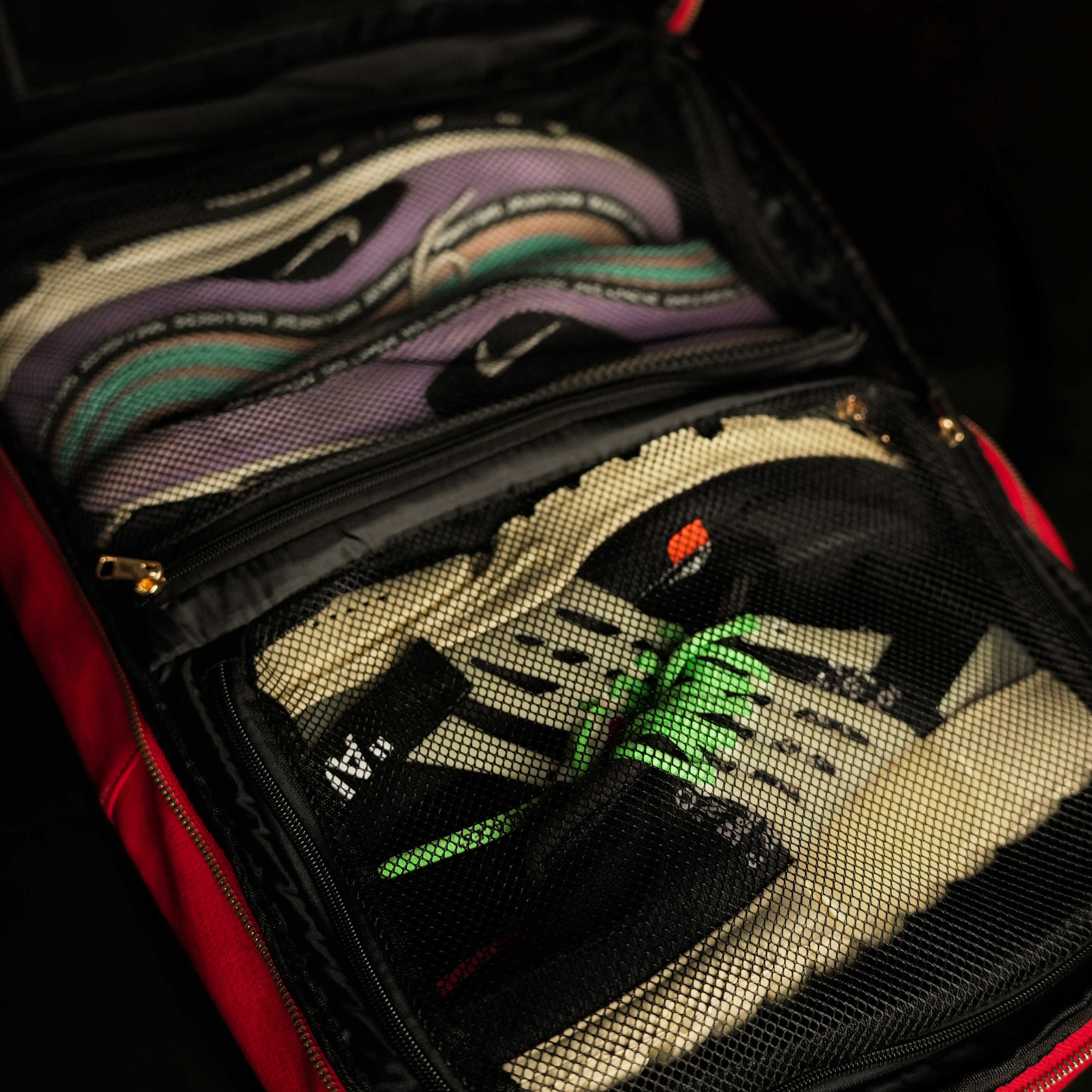 Open suitcase with a pair of shoes inside, showing brand logos.
