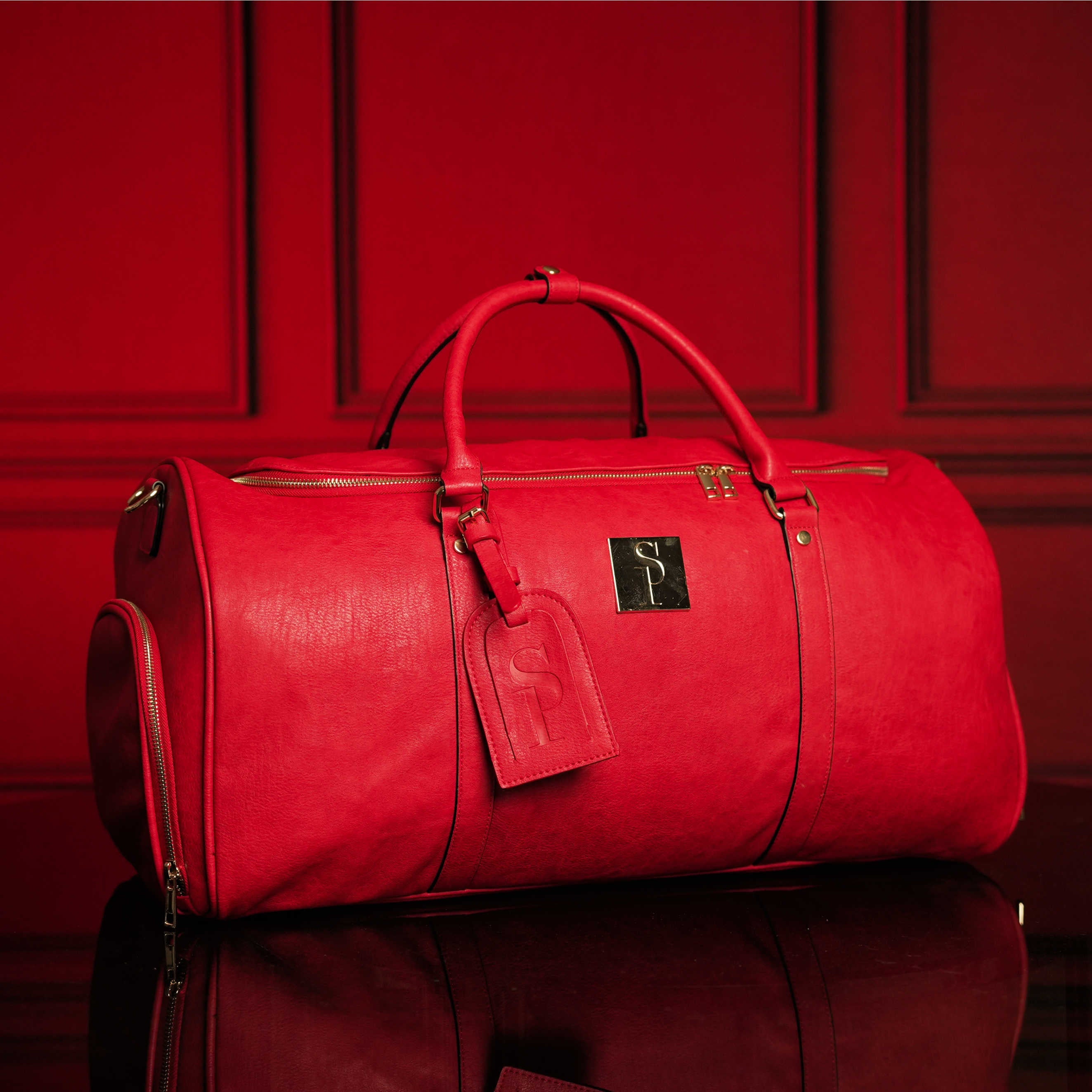 Red duffel bag with a visible brand logo on a red background