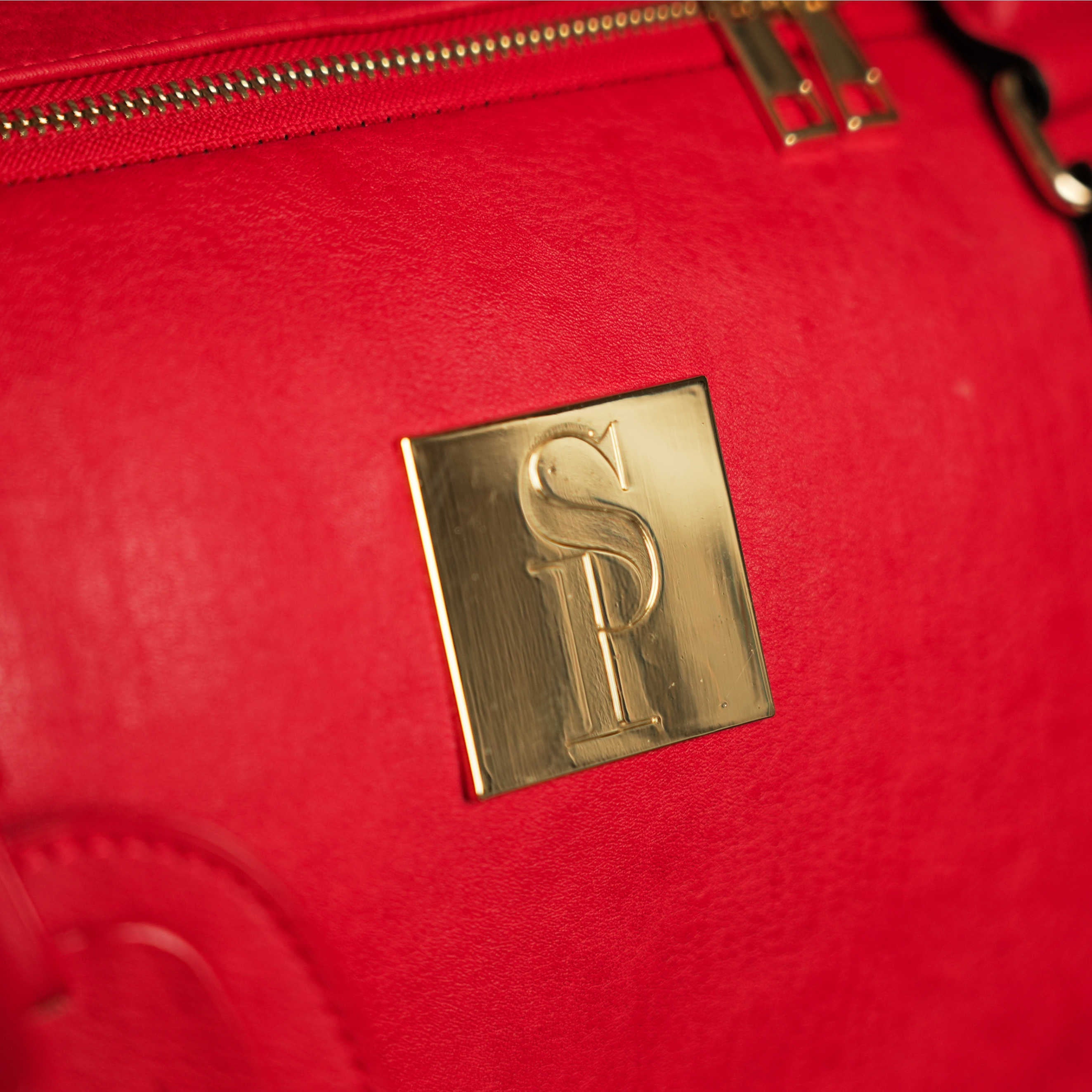 Red bag with a gold logo on a red background