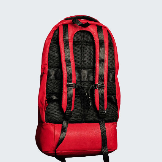 Red backpack with black straps on a red background