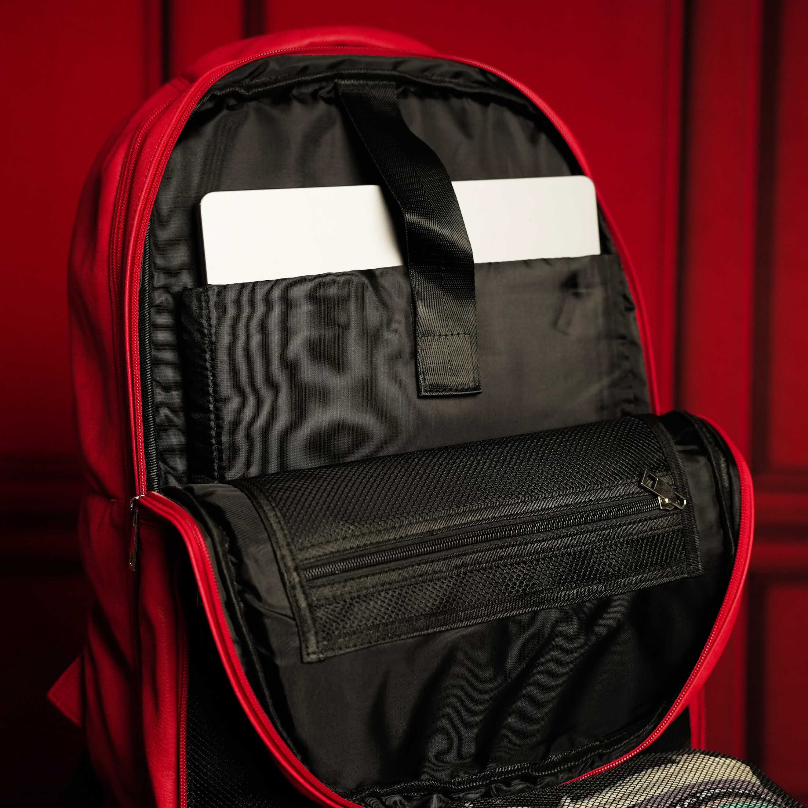 Red and black backpack with open compartment showing a white card on a red background