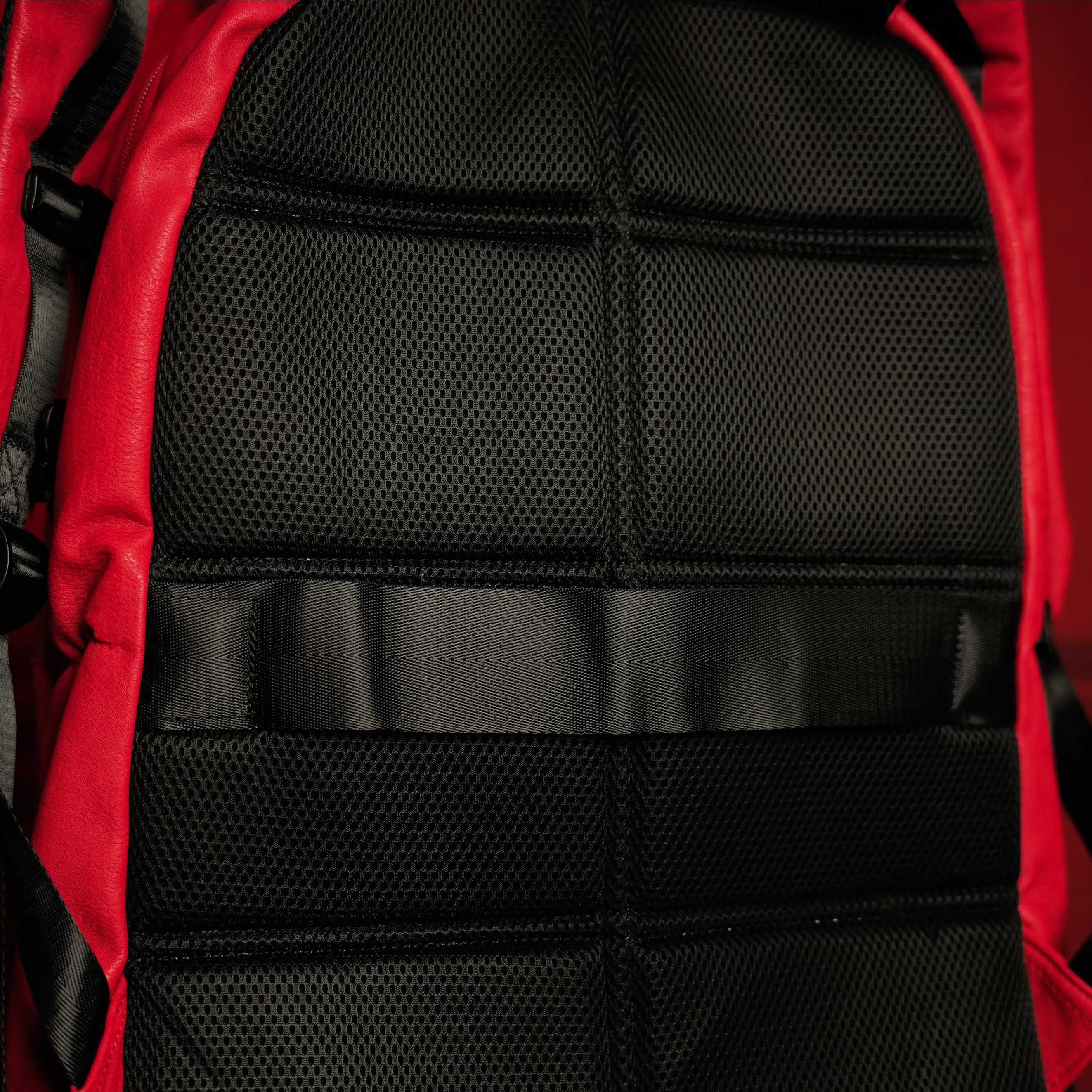 Close-up of a red and black backpack with a textured back panel.