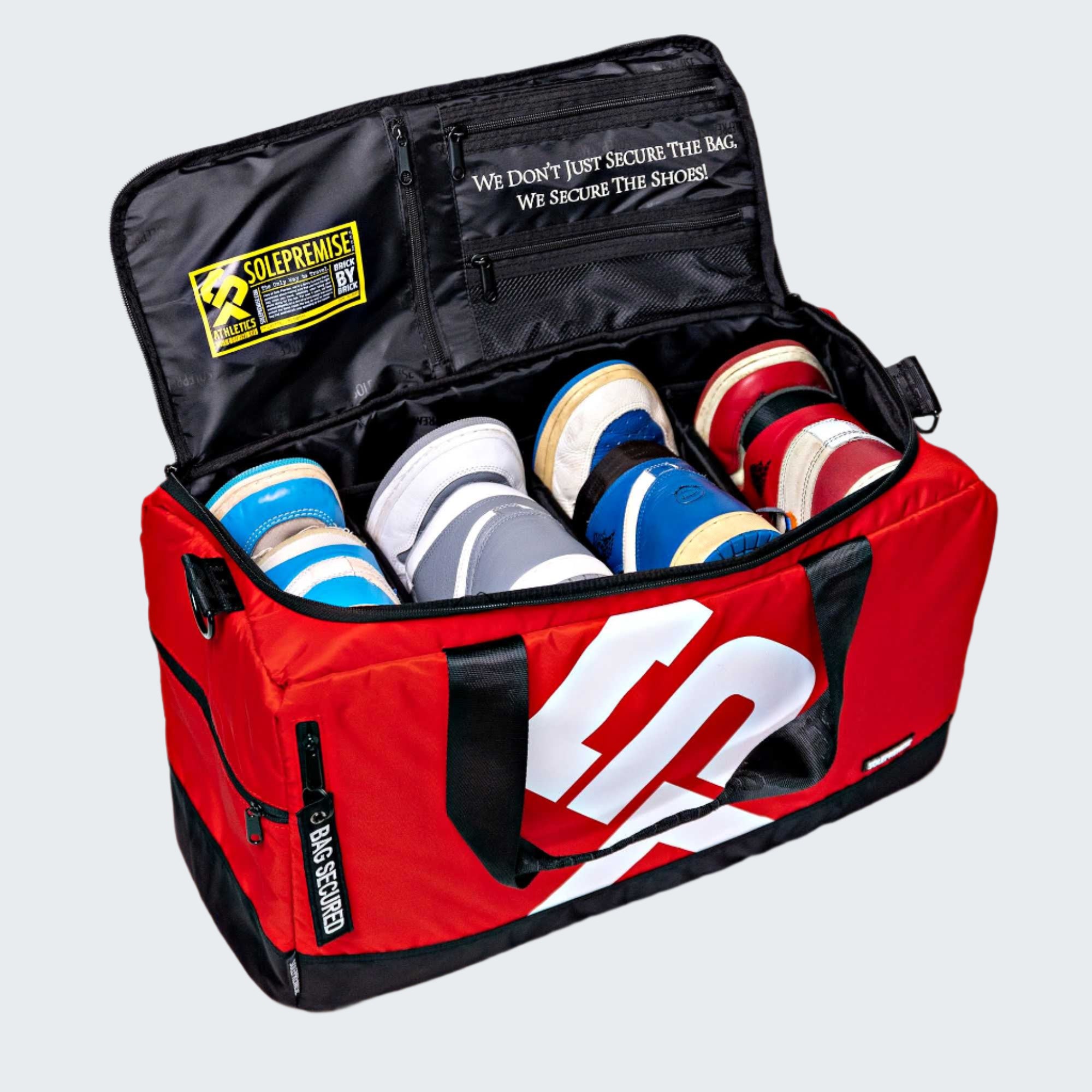 Red sports bag with white logo containing various shoes on a white background