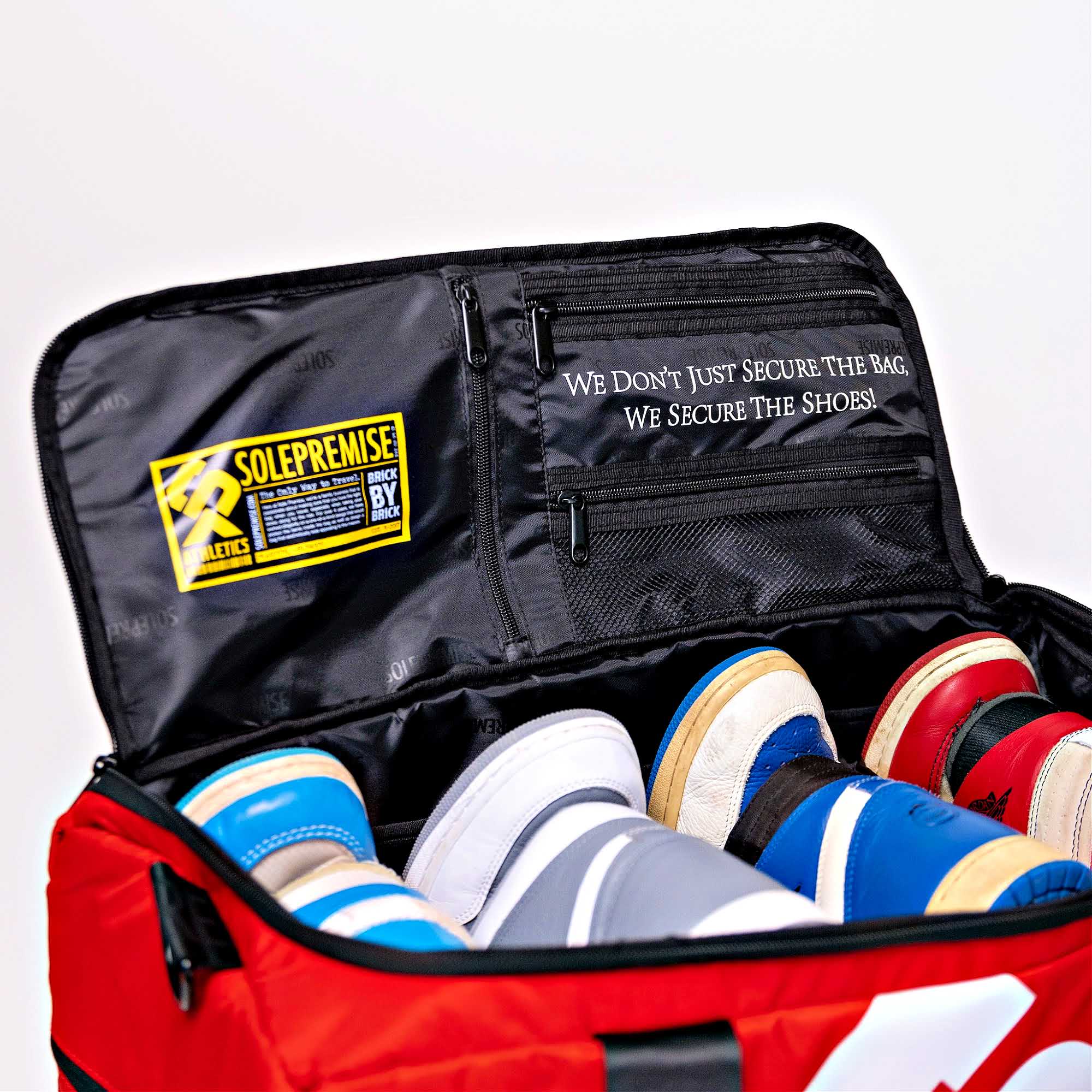 Red bag with black interior containing shoes, featuring Solepremise branding.