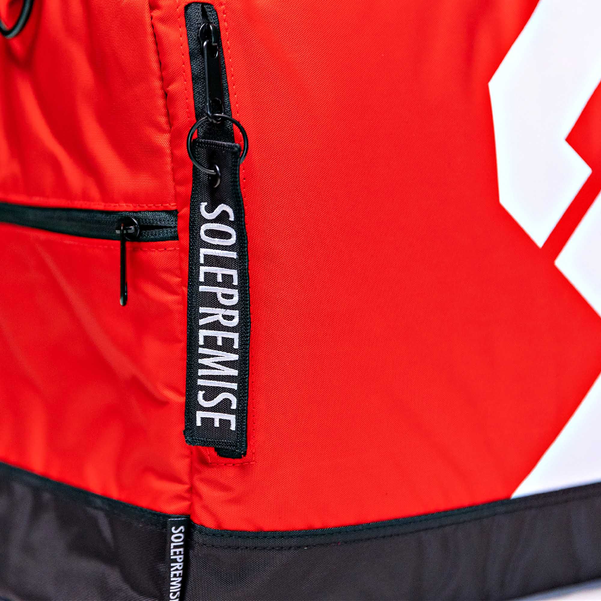 Red and black jacket with 'Solepremise' branding on a white background