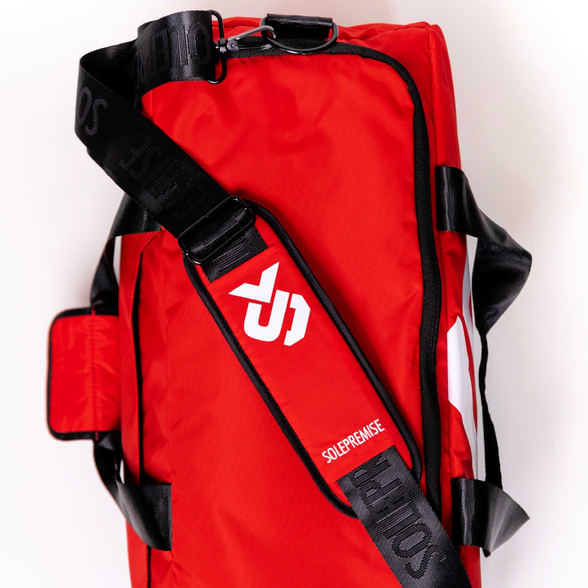 Red bag with black straps and a visible brand logo on a white background
