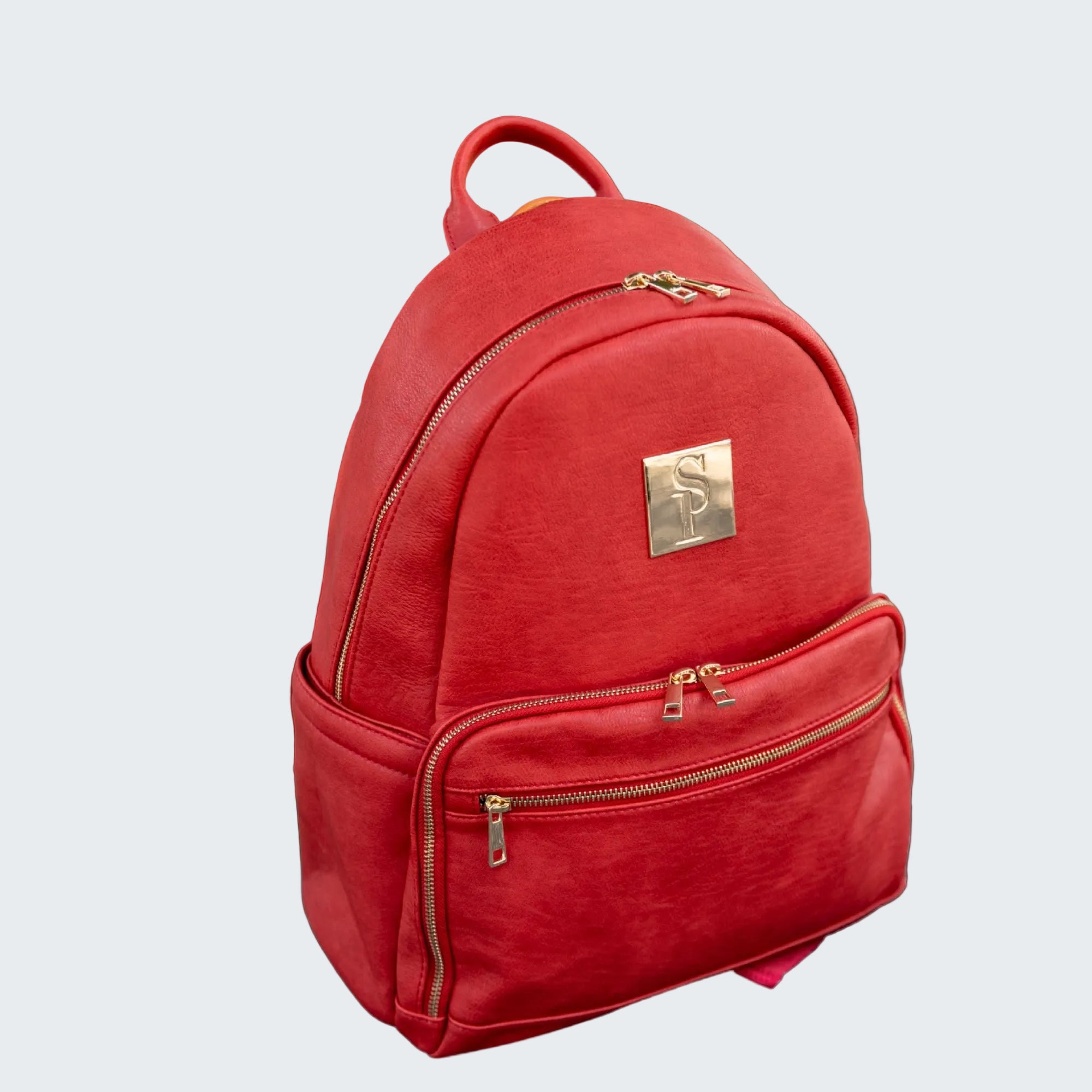 Red backpack with gold accents on a red background
