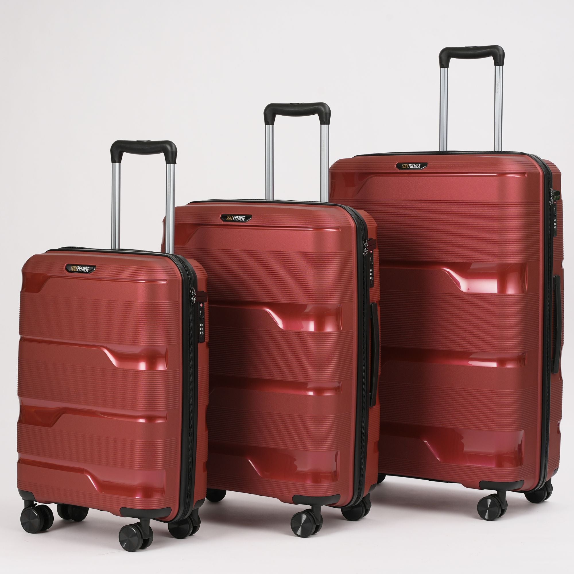 Three red suitcases of different sizes on a light gray background