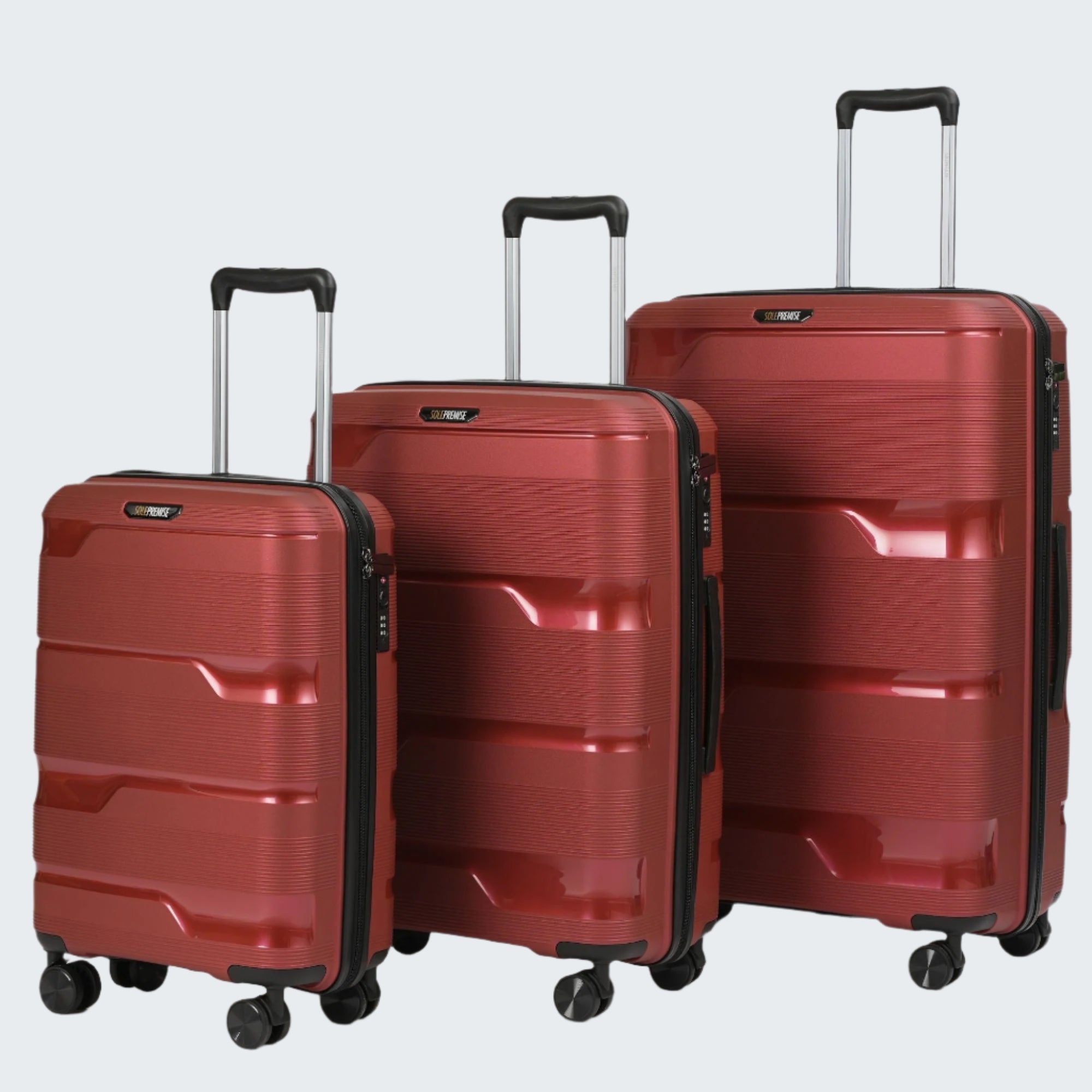 Three red suitcases of different sizes on a light gray background