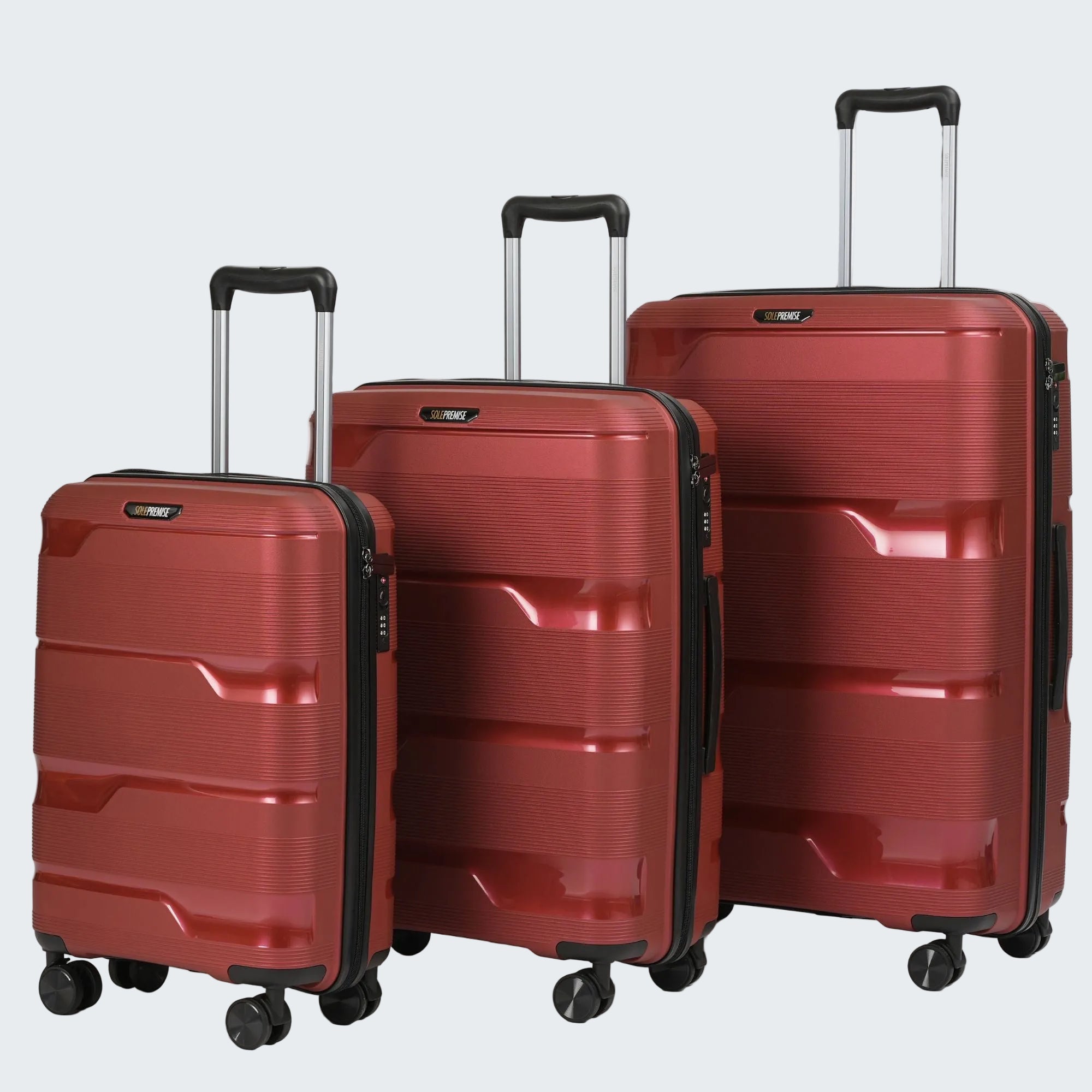 Three red suitcases of different sizes on a light gray background