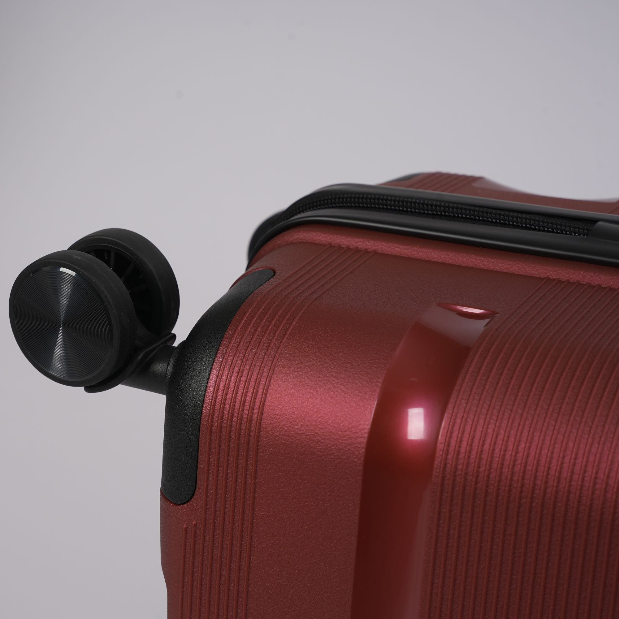 Red suitcase with black wheel on a gray background