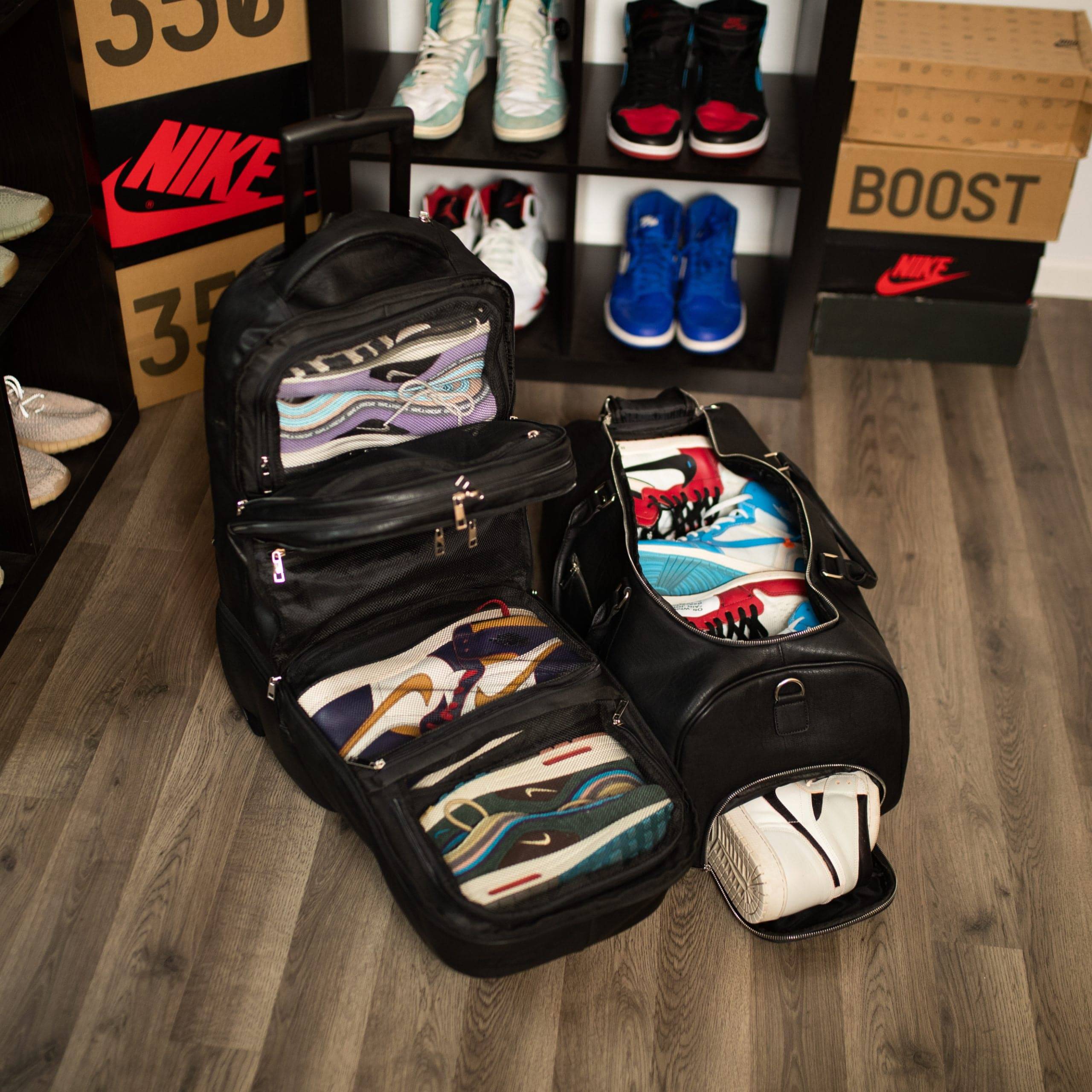 Black sneaker bag with shoes inside on a wooden floor, with Nike boxes in the background.