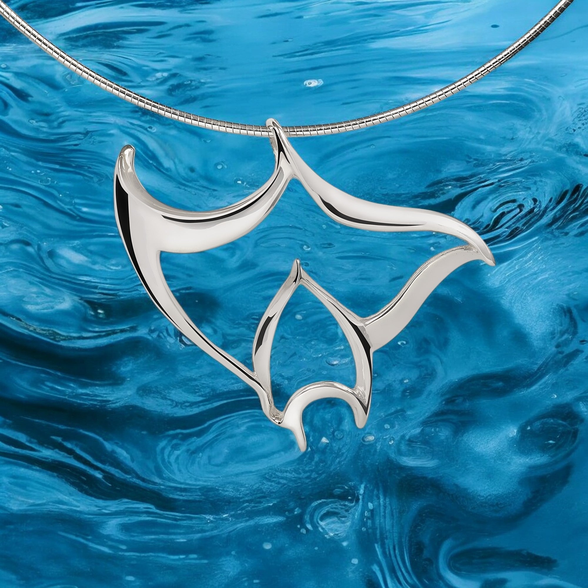 Silver pendant on a blue water background