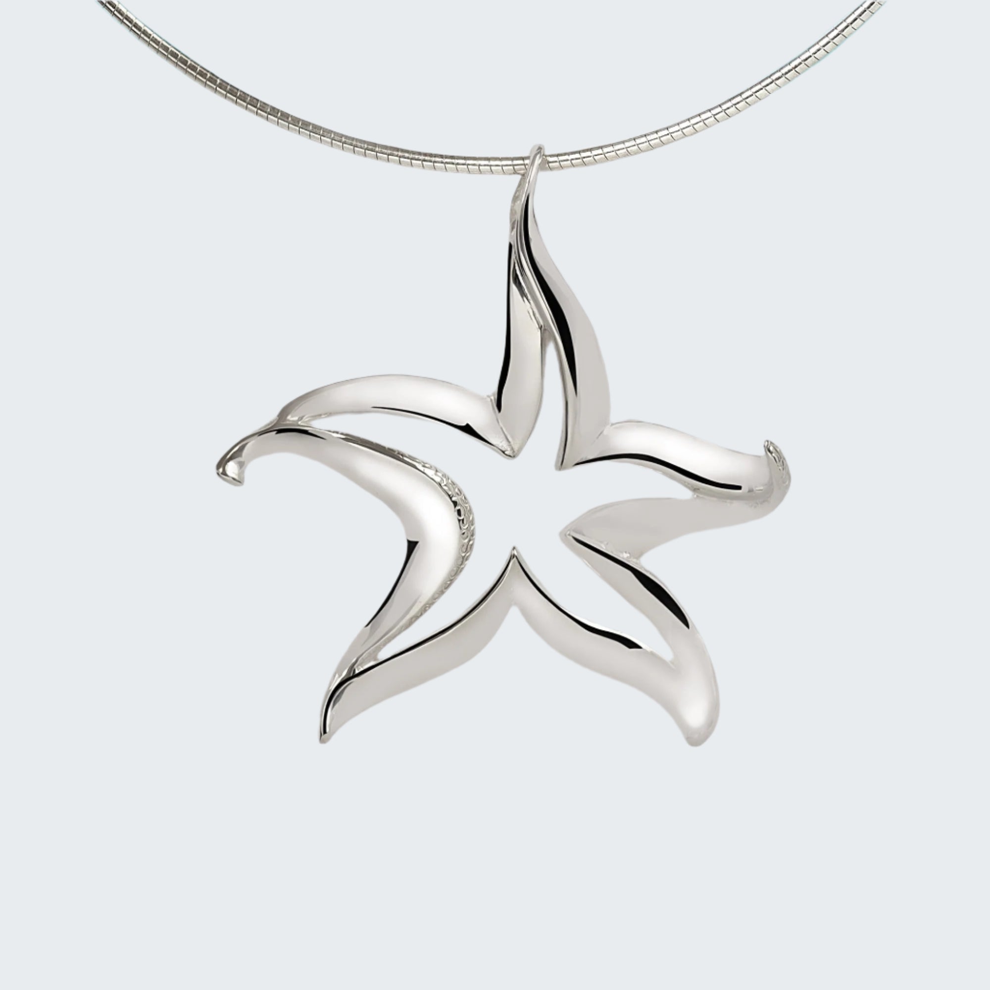 Silver starfish pendant on a white towel with a blue background