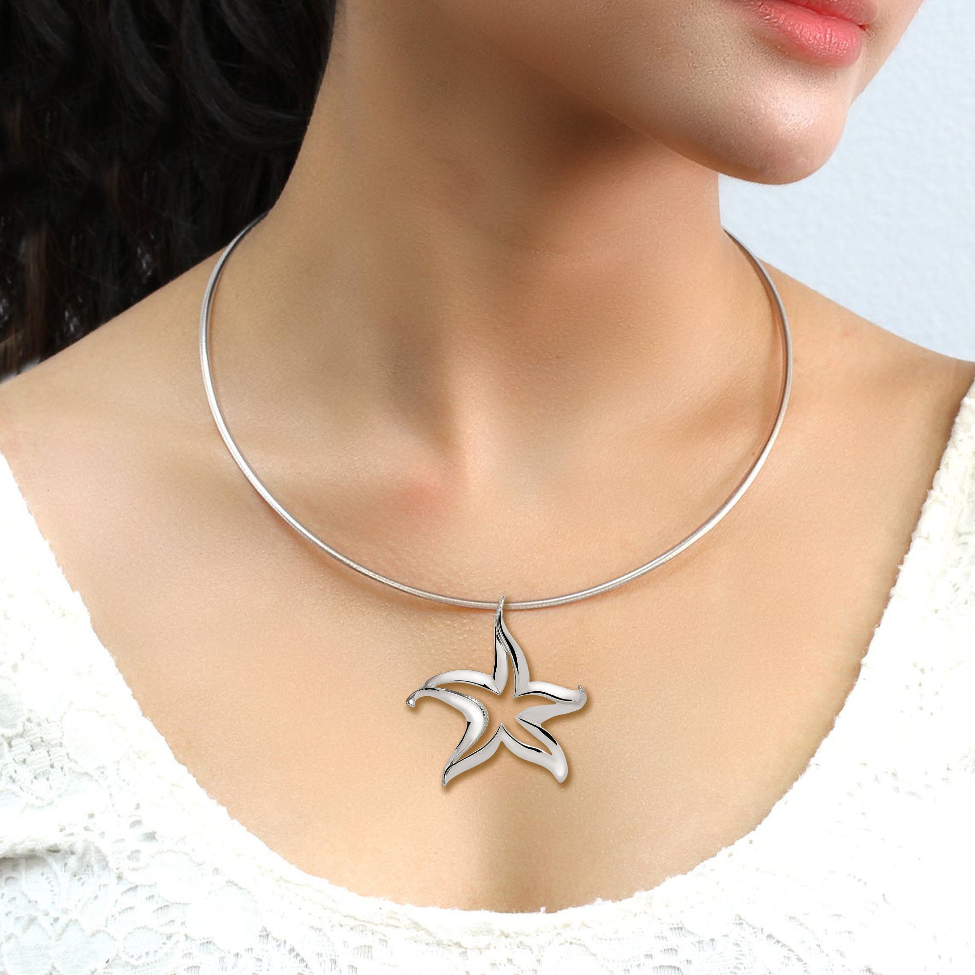 Silver necklace with a star-shaped pendant on a mannequin