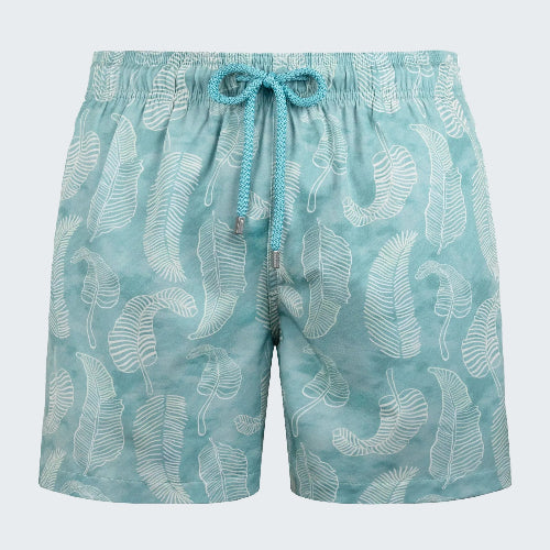 Teal swim shorts with white leaf pattern on a white background