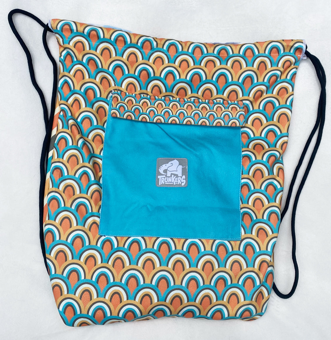 Drawstring bag with geometric pattern and teal pocket on a white background