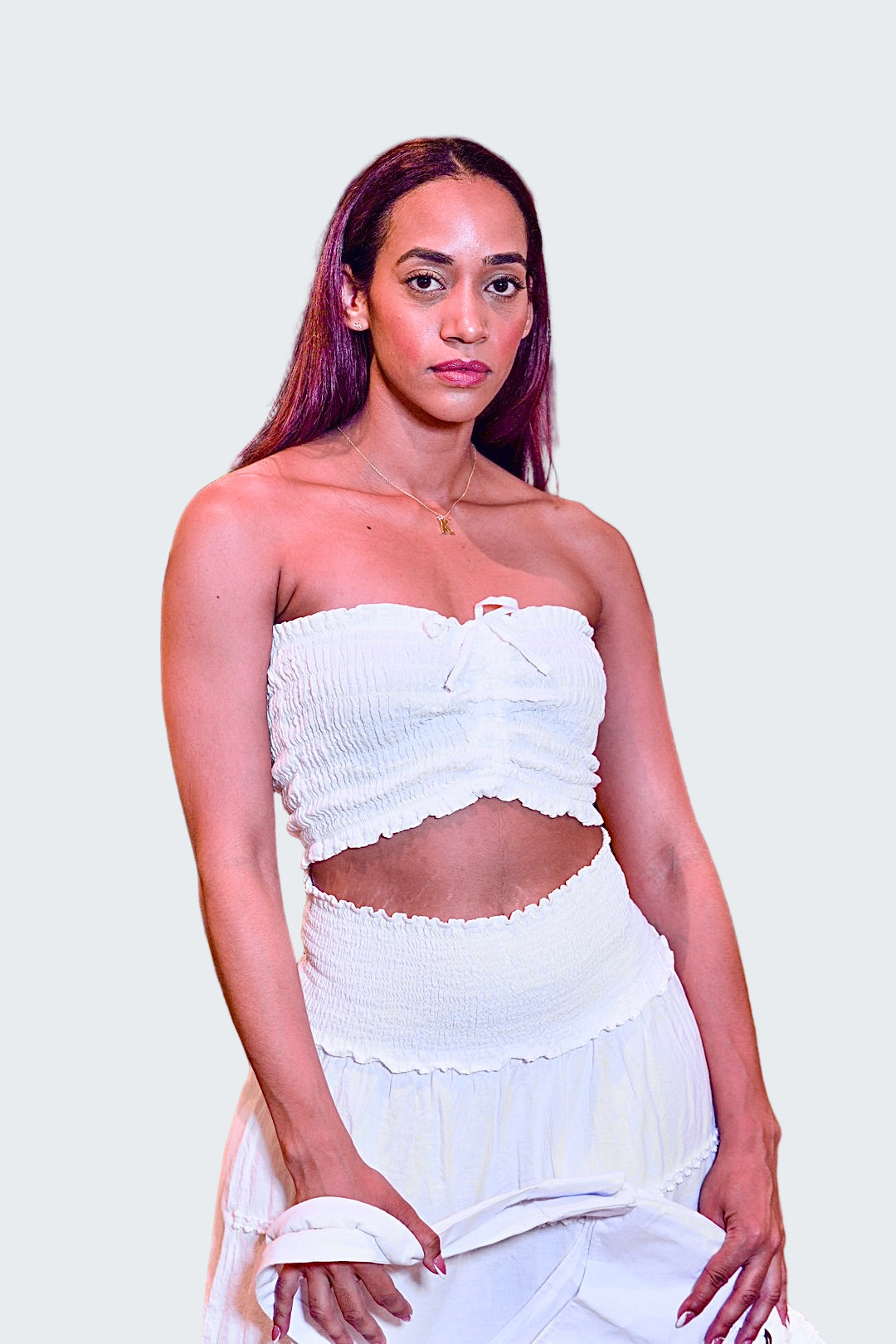 Woman wearing a white strapless top and skirt in an indoor setting