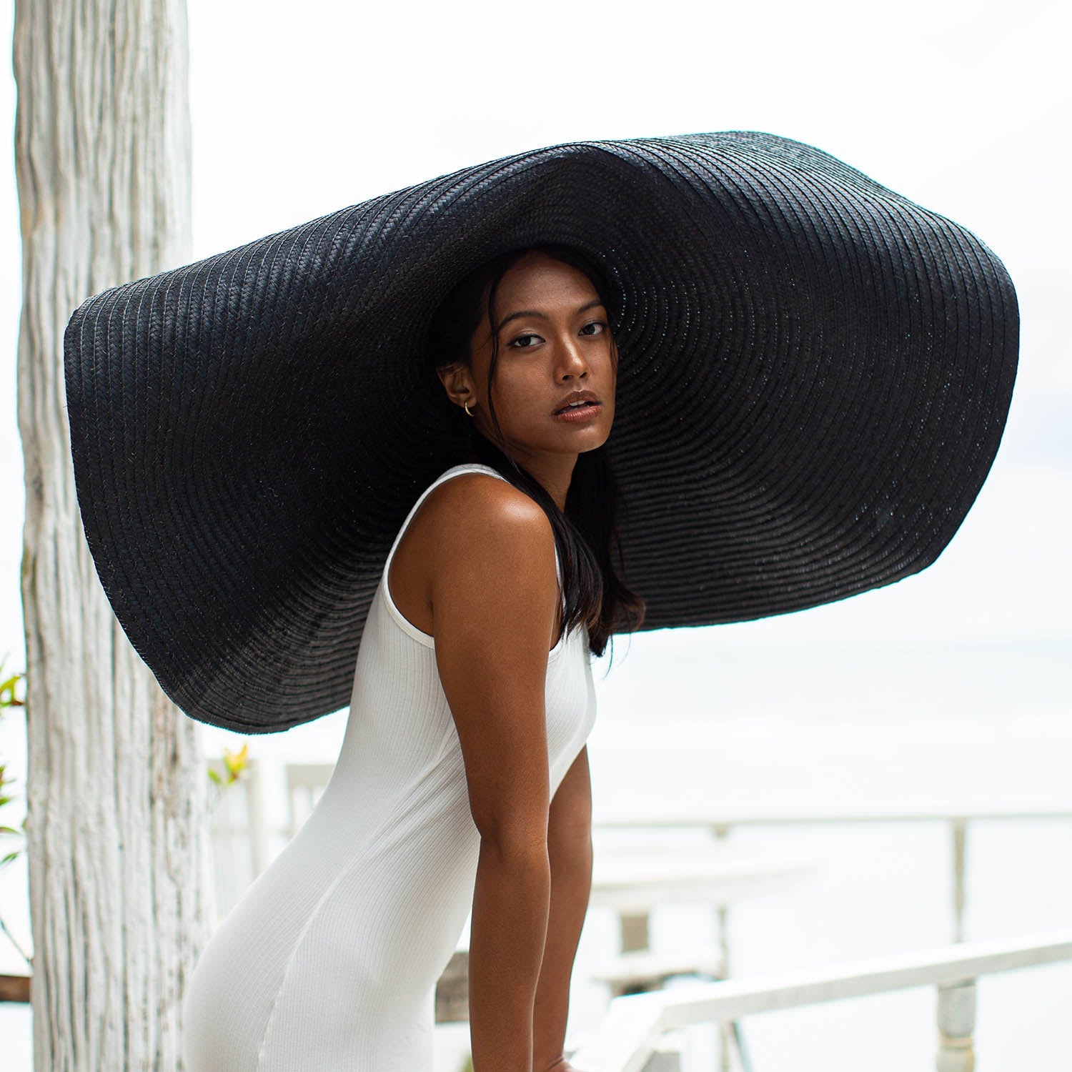 Woman wearing a large black sun hat outdoors