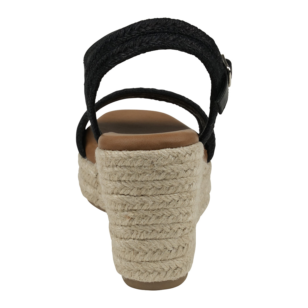 Black wedge sandal with woven sole on a white background