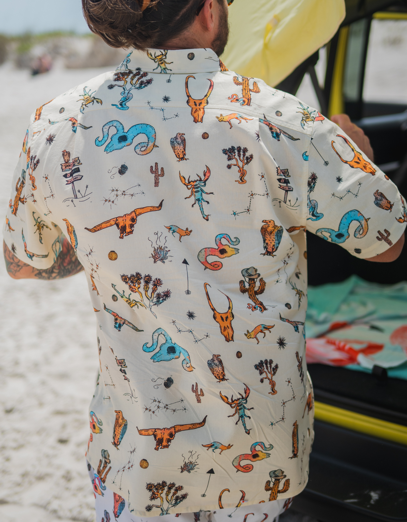 Person wearing a colorful patterned shirt with a blurred background