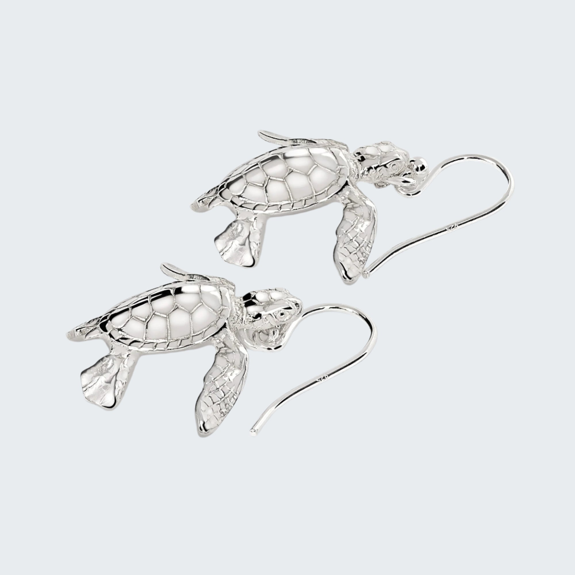 Silver turtle-shaped earrings on a light gray background
