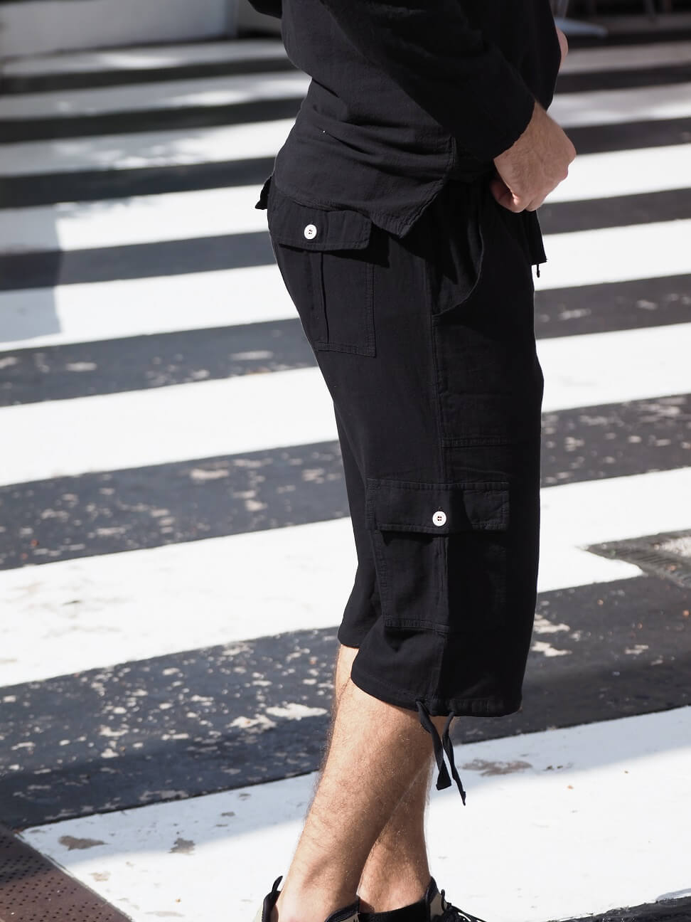 Person wearing black cargo shorts on a zebra crossing