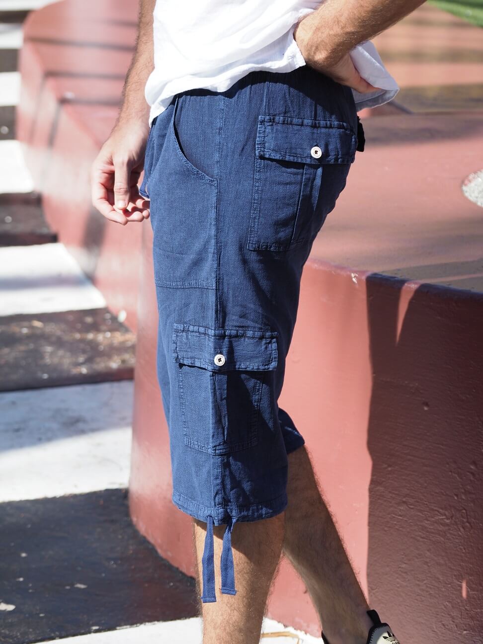 Person wearing blue cargo shorts with a blurred background