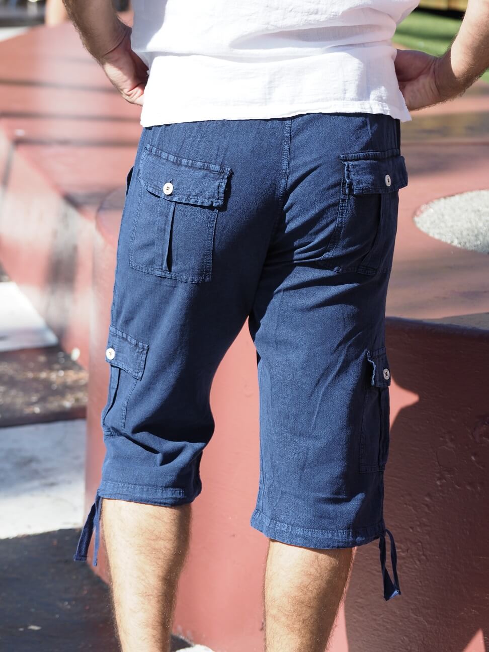 Person wearing blue cargo shorts with a blurred background