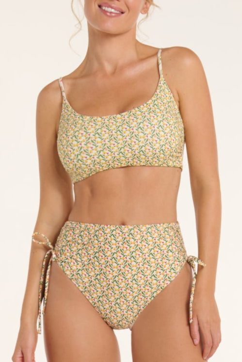 Woman wearing a floral two-piece swimsuit on a white background