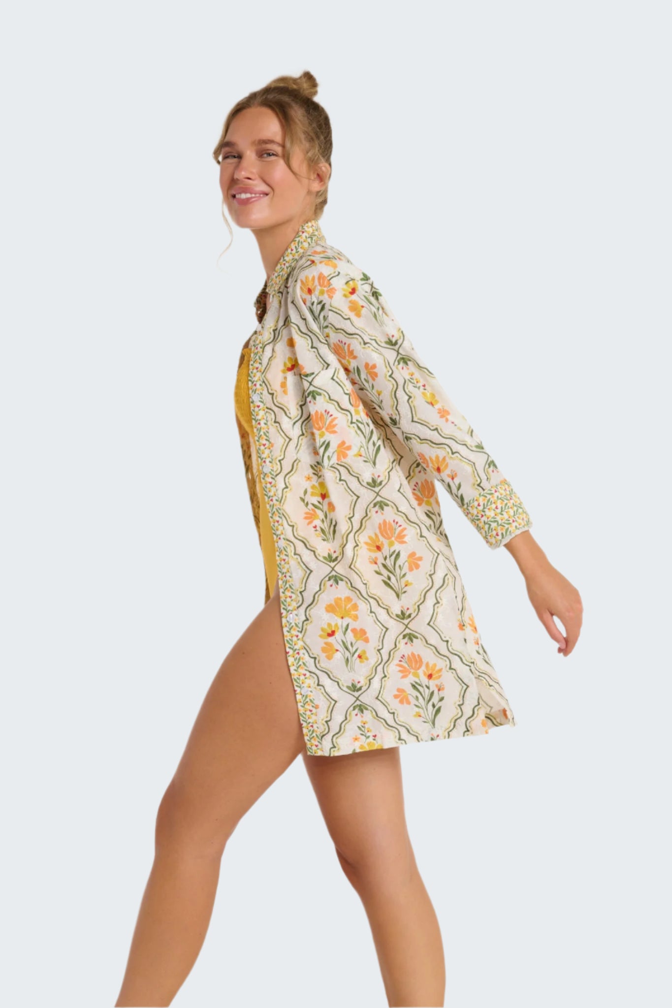 Woman wearing a floral kimono-style garment on a plain background