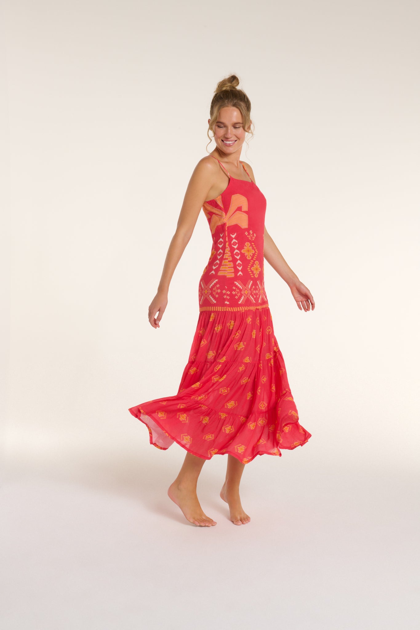 Woman wearing a red dress with a pattern on a white background