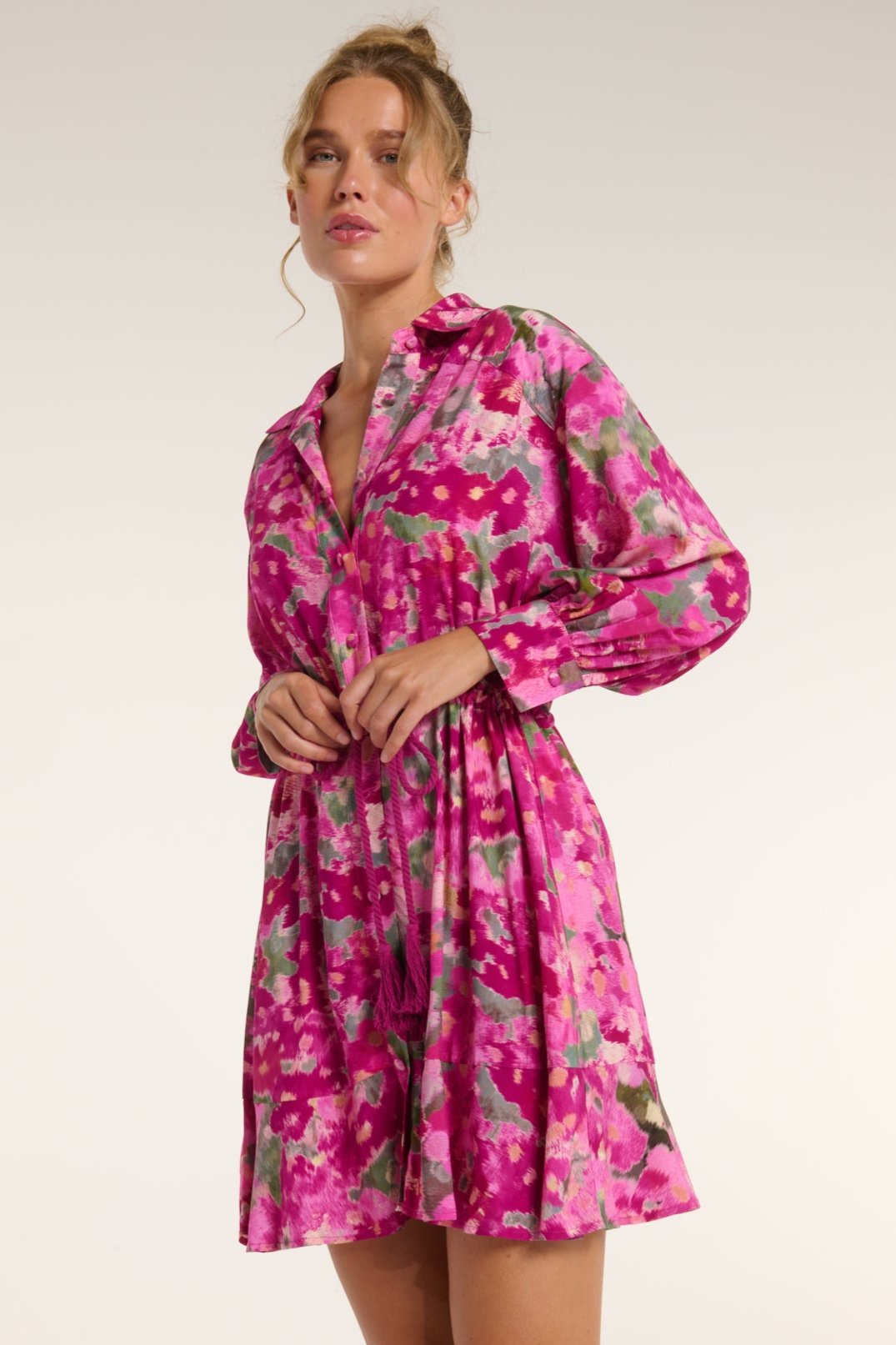 Woman wearing a pink floral dress against a white background