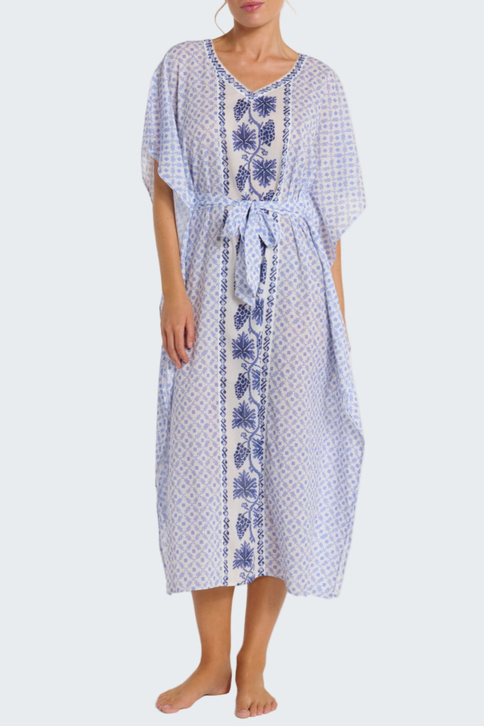 Woman wearing a blue and white patterned dress on a plain background