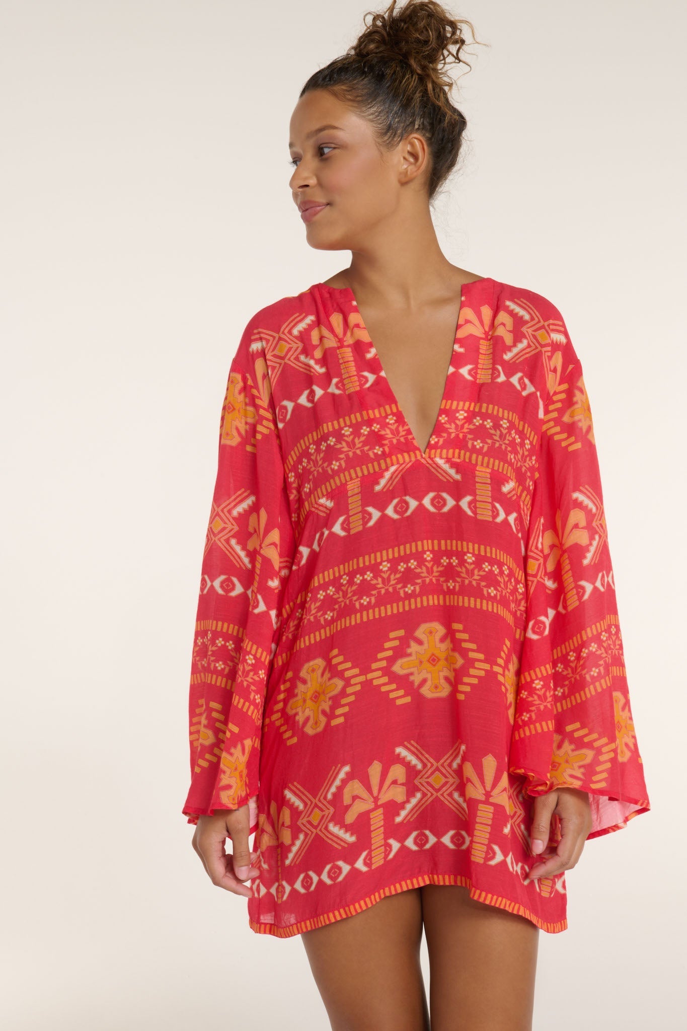 Woman wearing a red patterned cover-up against a white background