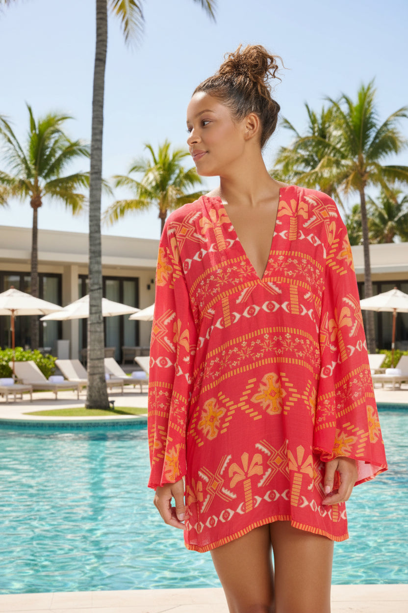 Woman wearing a red patterned cover-up against a white background